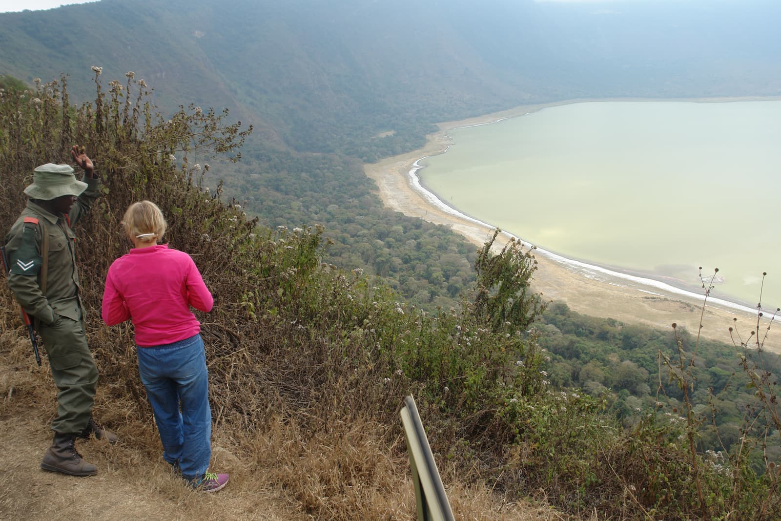Walkers on the forested rim above the lake in Empakaai Crater