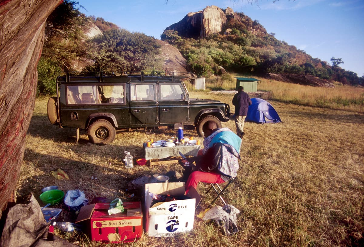 A safari vehicle and tents at a campsite in the Serengeti